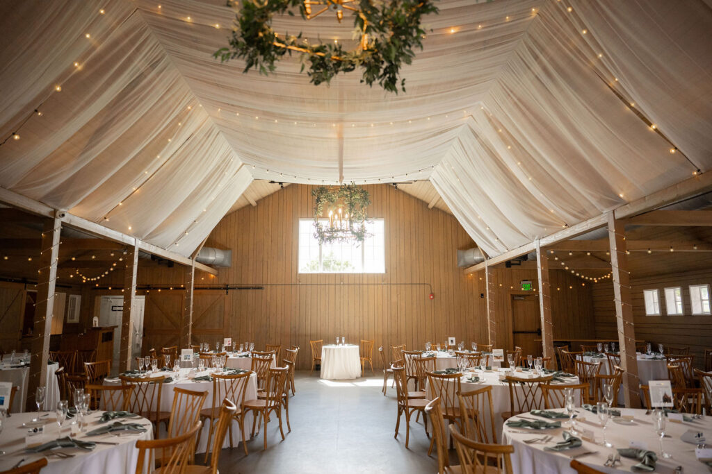 barn interior wrapped in soft, draped fabric and warm string lights