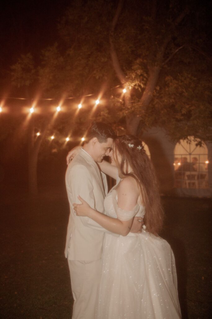 Bride and groom embracing at night.