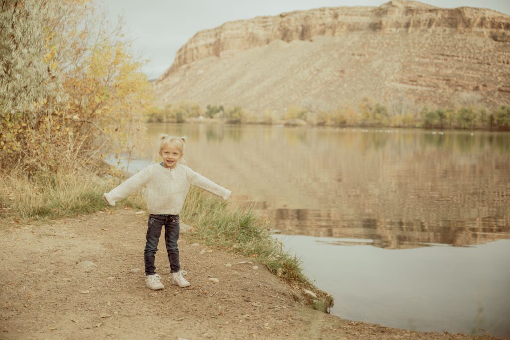Child by a lakeside in autumn.