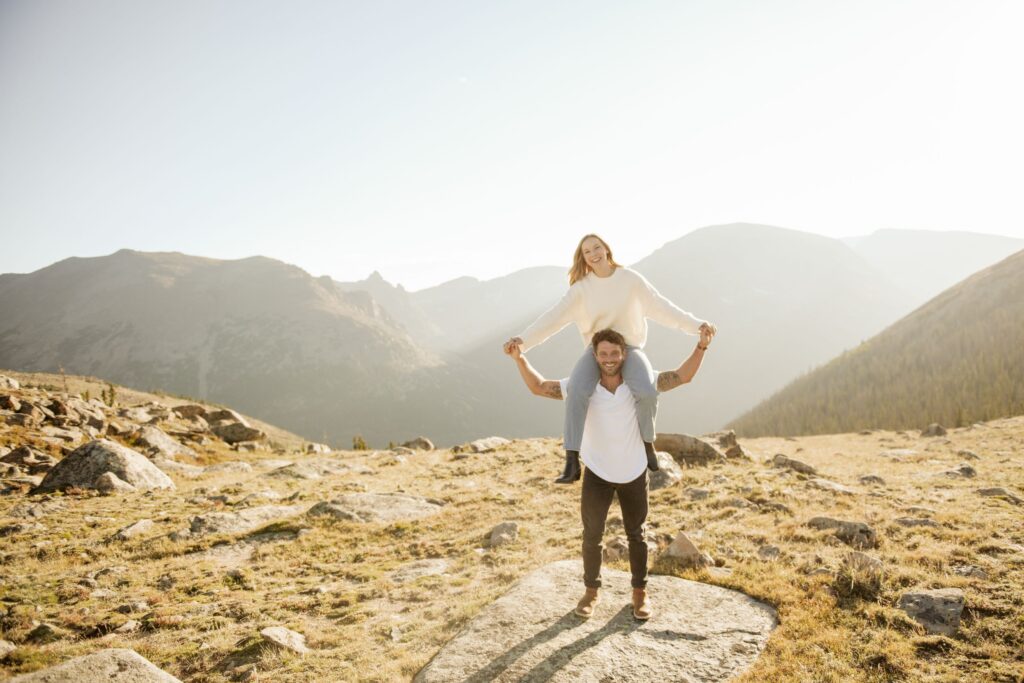 Couple Piggyback in Rocky Mountain Landscape at Sunset