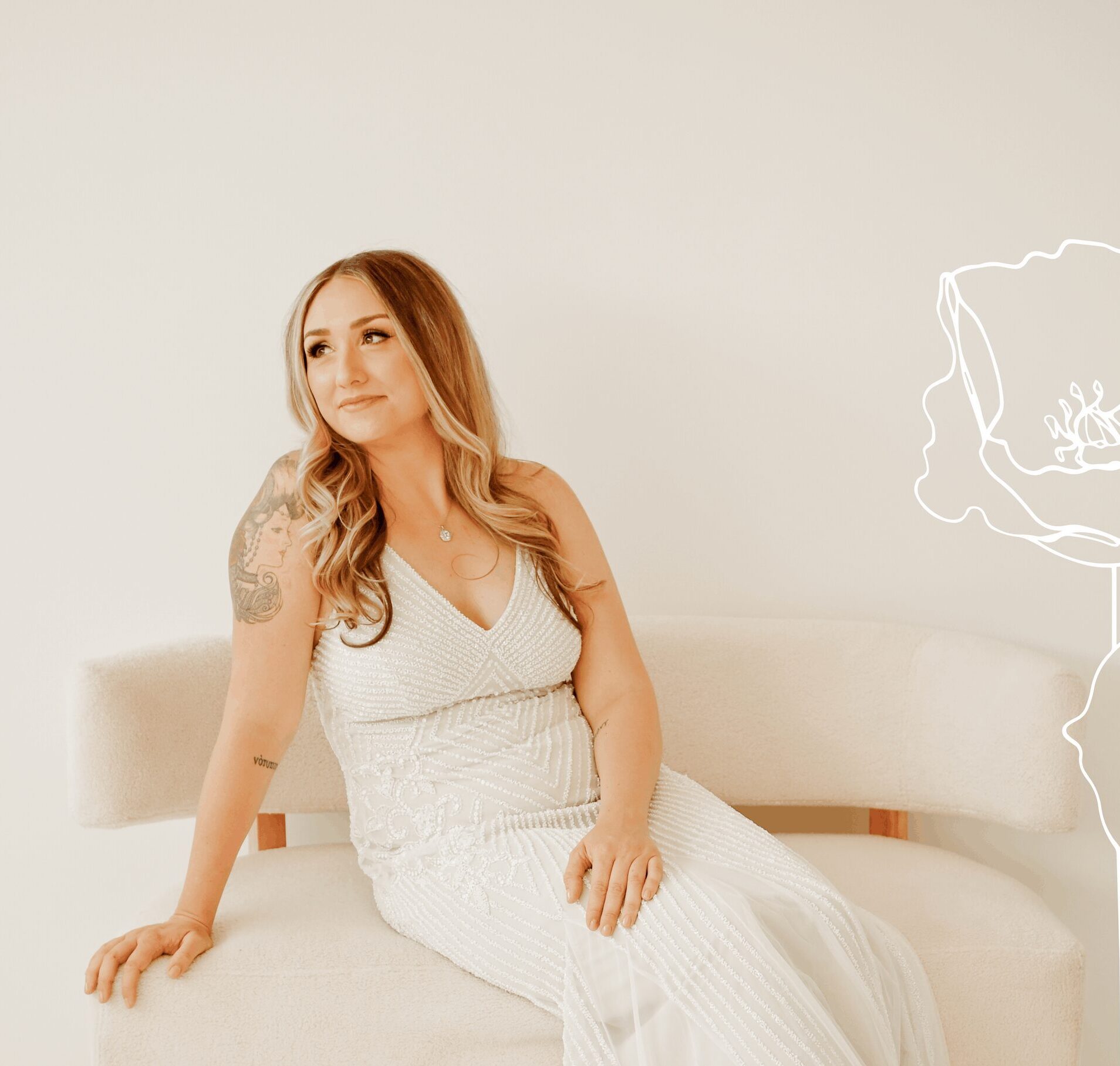 Bride sitting on a bench in a beaded white dress.