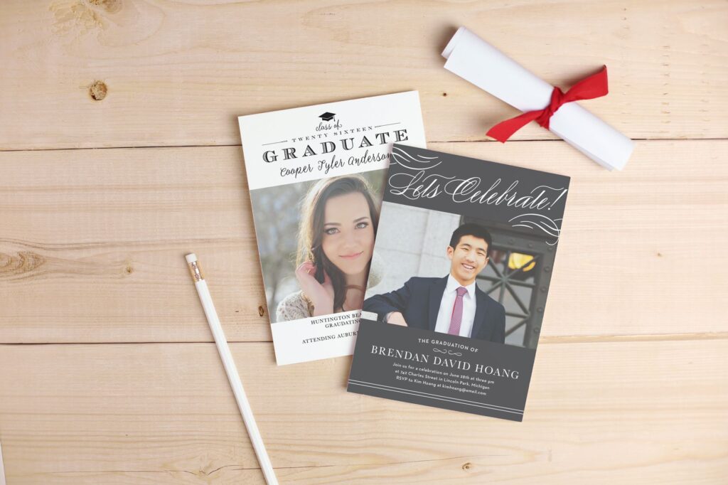 Two graduation announcement cards with photos laid on a wooden table.