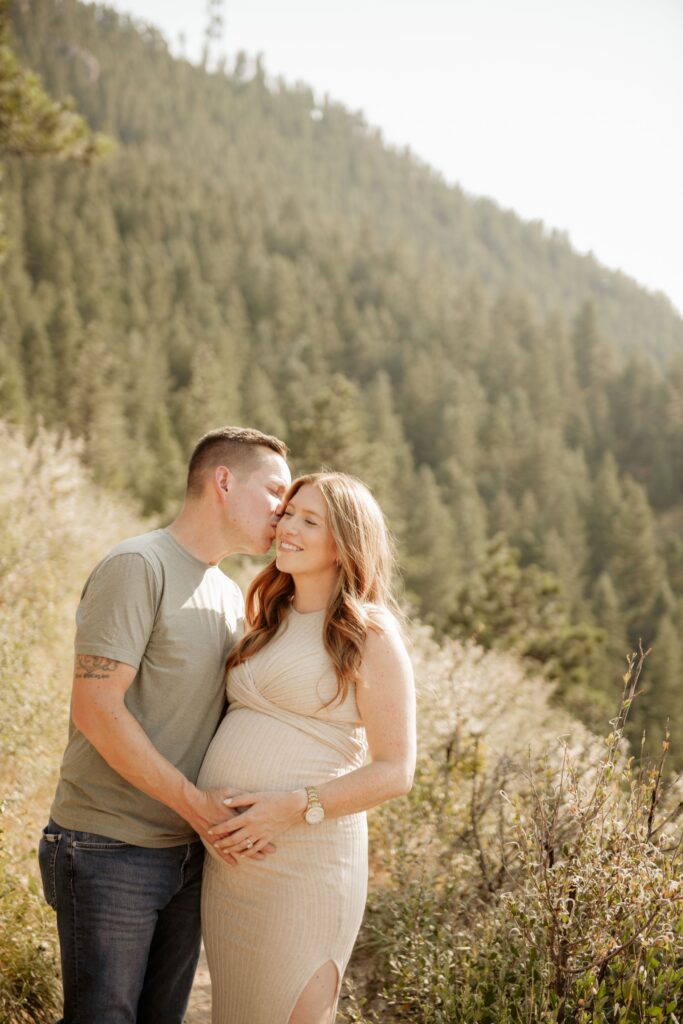 Couple embracing during a mountain maternity photoshoot