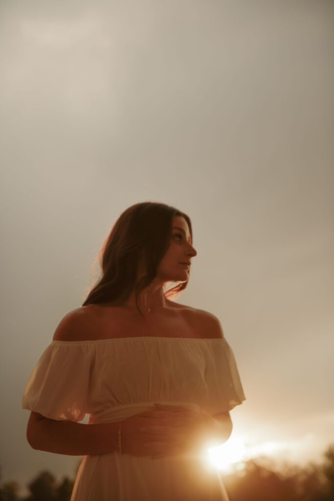 Woman in an off-shoulder dress at sunset.