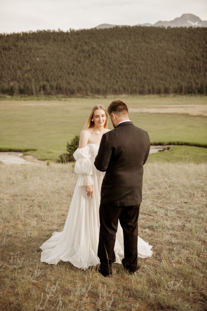 Bride and groom sharing a quiet moment in a scenic mountain landscape.