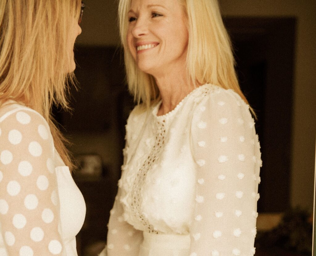 Two women smiling at each other in a close, candid moment.