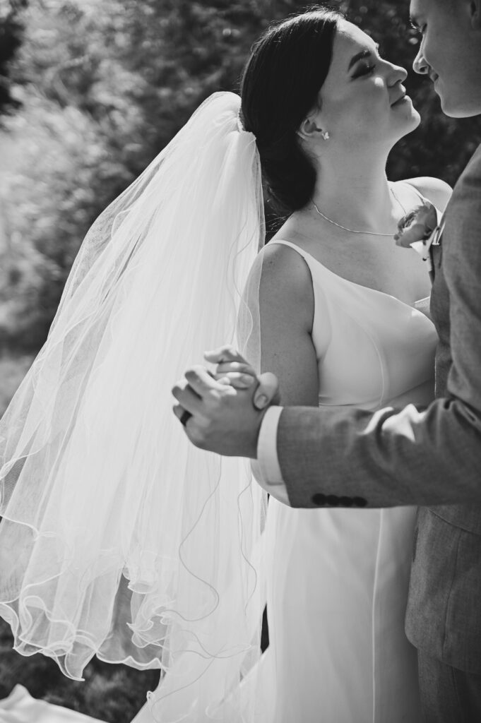 Black and white photo of a bride and groom holding hands.