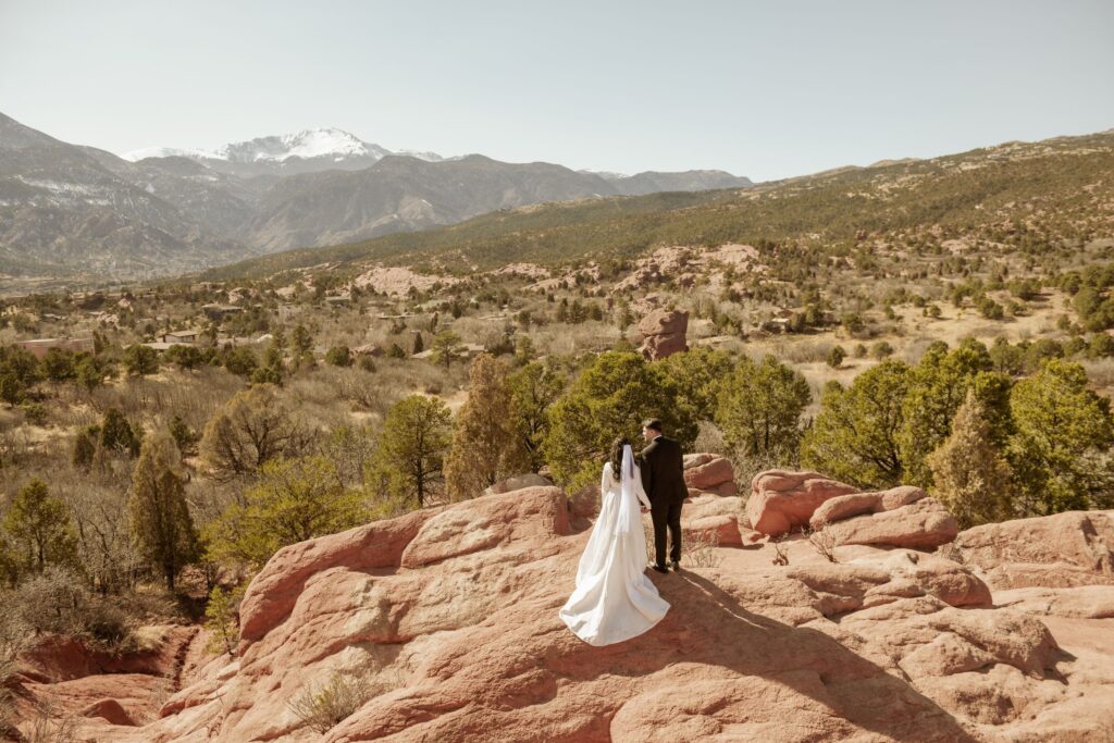 Bride and groom overlooking a scenic mountain landscape after their ceremony.