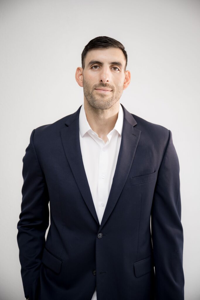 Man in navy suit posing for a professional business headshot