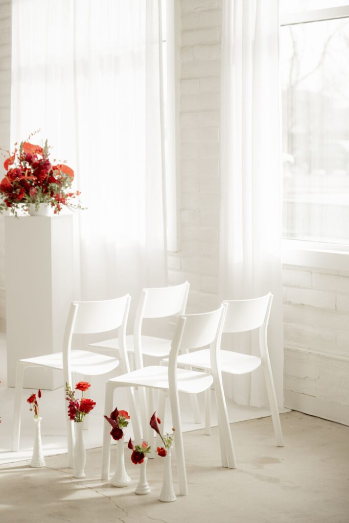 Minimalist wedding ceremony chairs with floral décor.
