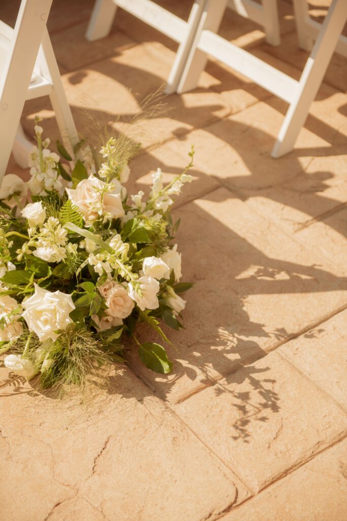 Wedding ceremony aisle floral arrangements.
