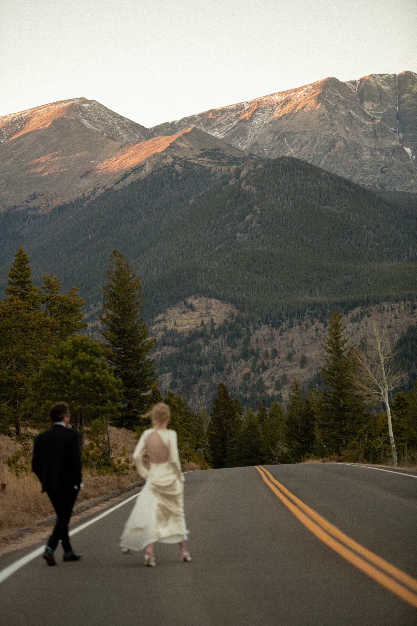 Bride and groom by the mountains at sunset