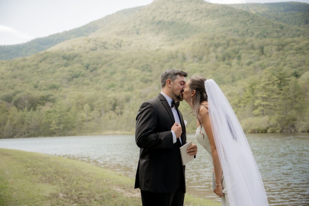 Bride and Groom kissing by lake