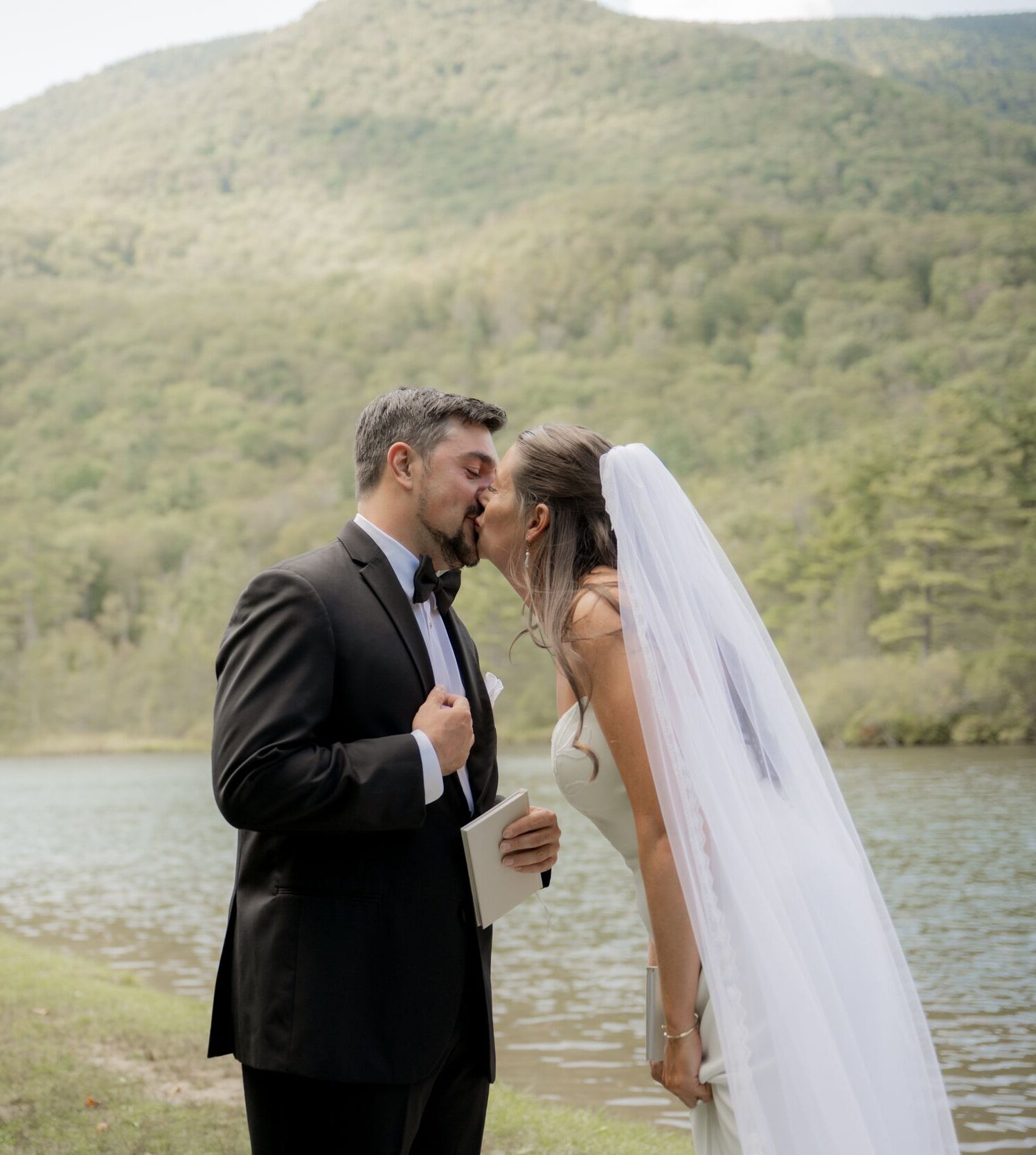 Bride and Groom kissing by lake