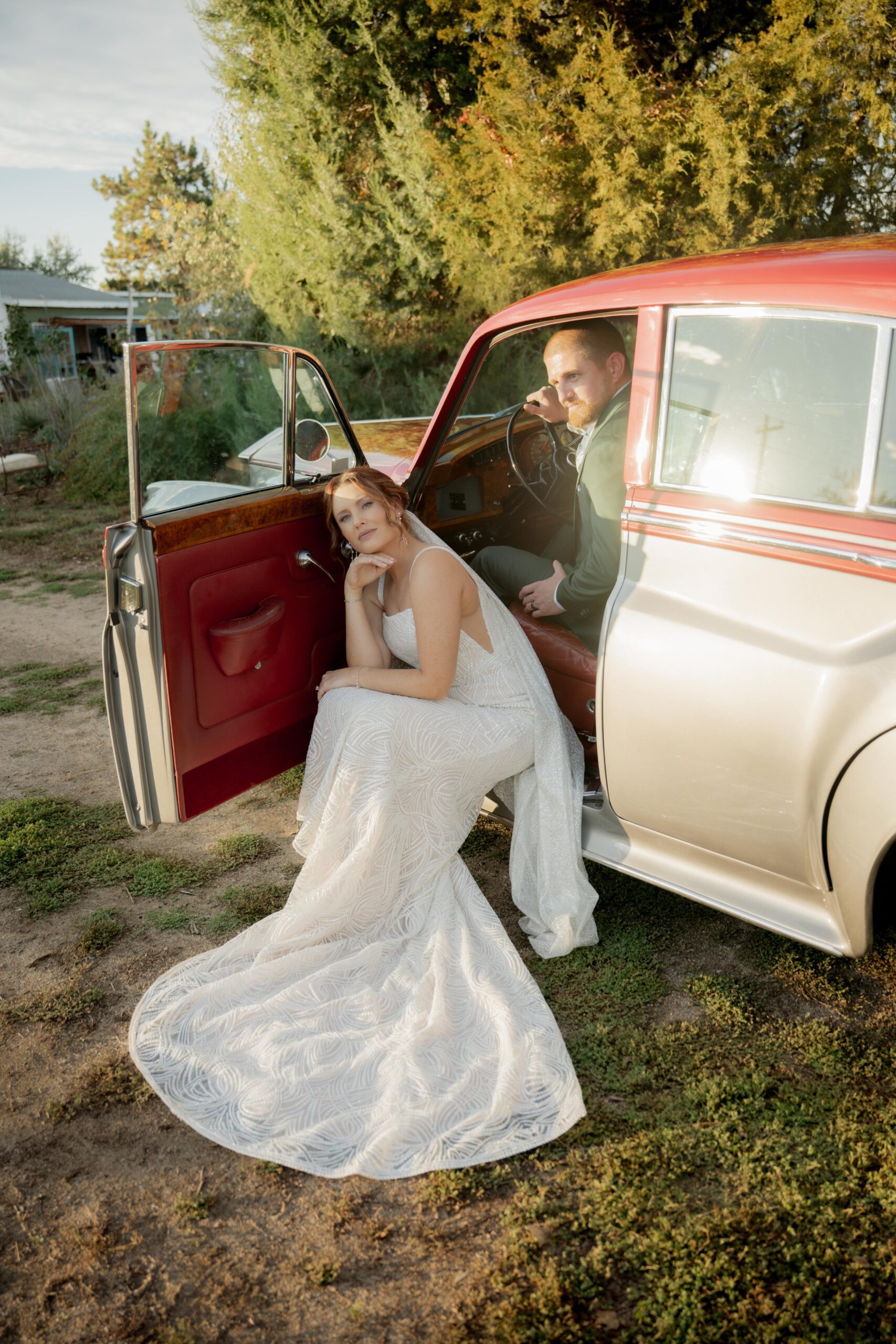 Bride and groom sitting in a car